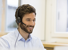 Friendly shipping serviceman on phone with a Bonnyville customer.